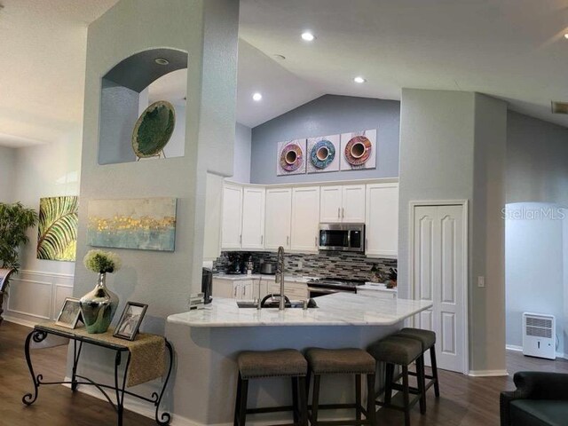 kitchen featuring tasteful backsplash, white cabinets, stainless steel appliances, dark hardwood / wood-style floors, and sink