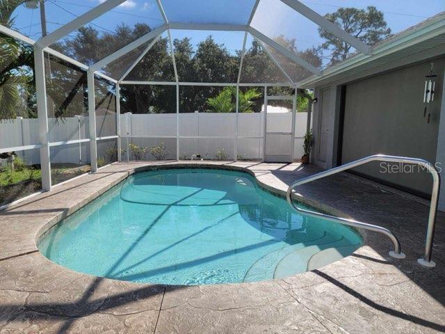 view of pool with a patio and glass enclosure