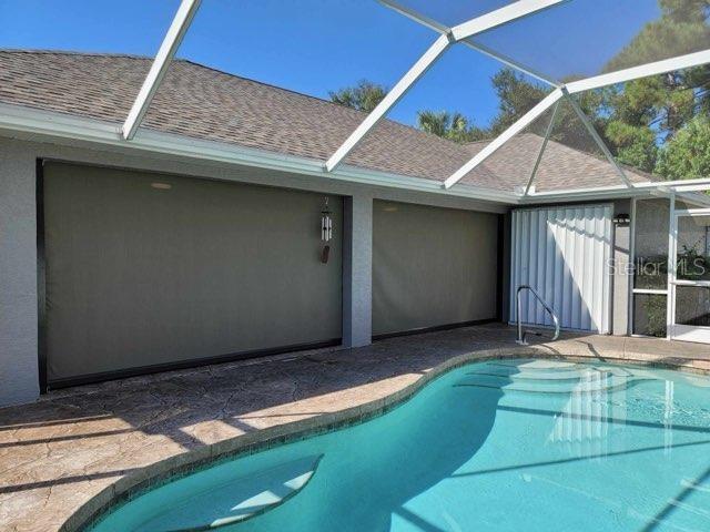 view of swimming pool with a patio and a lanai