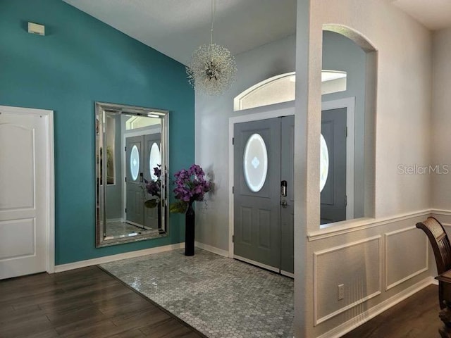 foyer with dark hardwood / wood-style floors and a notable chandelier