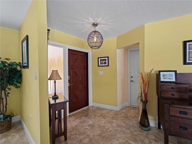 foyer with an inviting chandelier and a textured ceiling