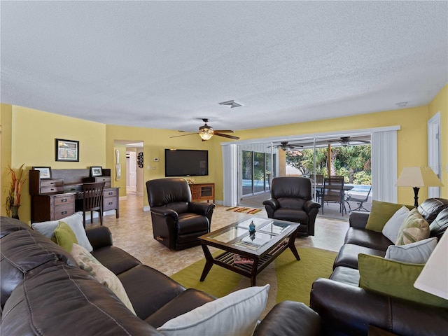 living room with a textured ceiling and ceiling fan