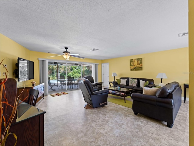 living room with ceiling fan and a textured ceiling