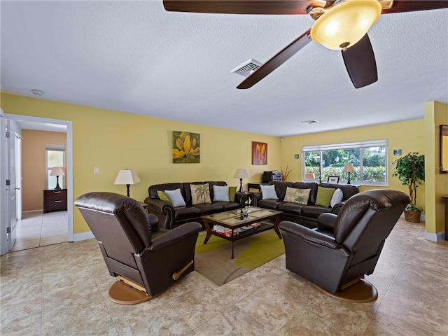 living room with ceiling fan and a textured ceiling