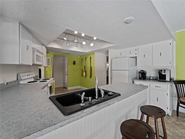 kitchen featuring white cabinets, white appliances, and a textured ceiling