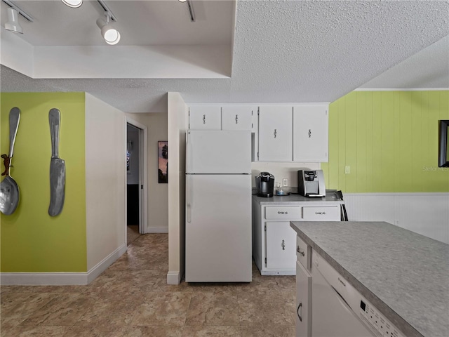 kitchen featuring a textured ceiling, rail lighting, white appliances, and white cabinets