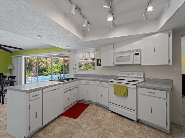 kitchen featuring a textured ceiling, white appliances, sink, and white cabinets