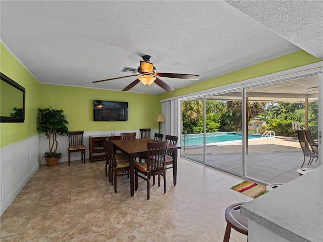 dining space featuring a textured ceiling and ceiling fan