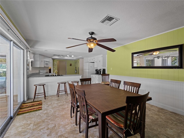 dining room with ceiling fan, a textured ceiling, and sink