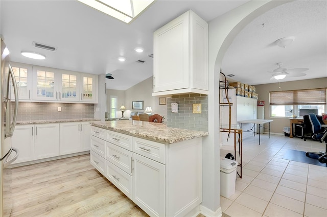 kitchen featuring white cabinetry, ceiling fan, and decorative backsplash