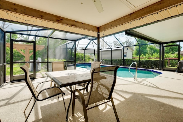 view of swimming pool with a patio, ceiling fan, and glass enclosure