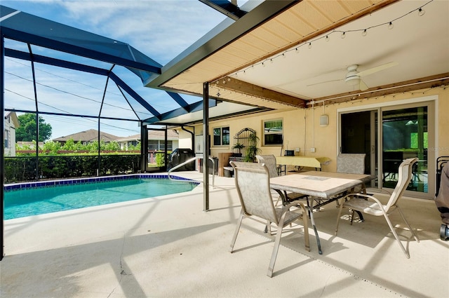 view of swimming pool with a patio, glass enclosure, and ceiling fan