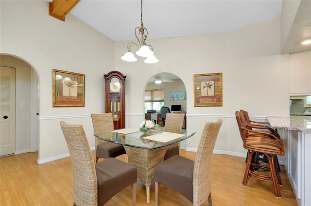 dining area with light hardwood / wood-style flooring, a chandelier, beamed ceiling, and high vaulted ceiling