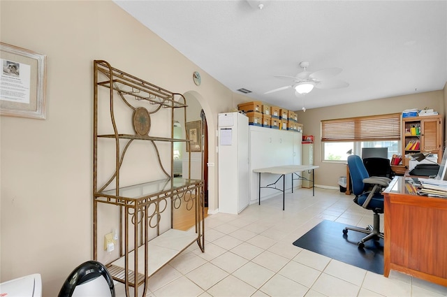 tiled home office featuring ceiling fan