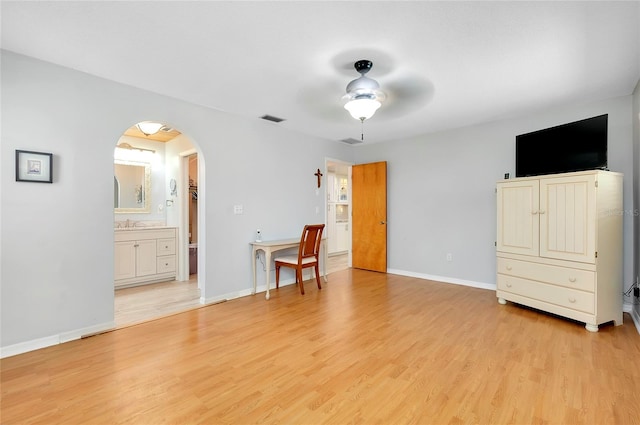 bedroom with light hardwood / wood-style flooring, ensuite bathroom, and ceiling fan