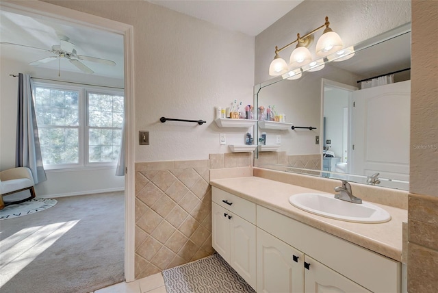 bathroom featuring tile walls, tile patterned floors, ceiling fan, and vanity