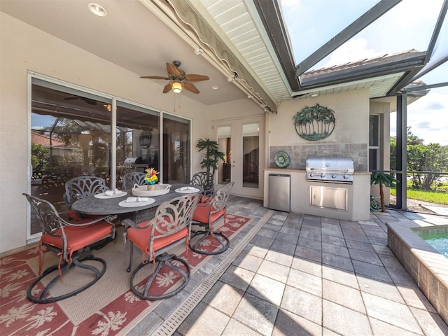 view of patio / terrace with ceiling fan, area for grilling, exterior kitchen, and glass enclosure