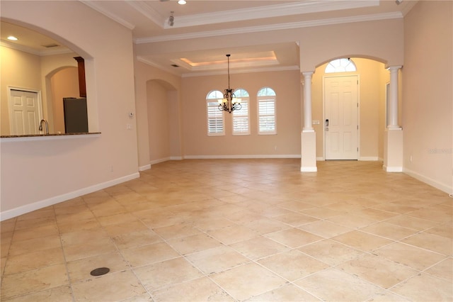 unfurnished room featuring sink, a raised ceiling, crown molding, and a chandelier