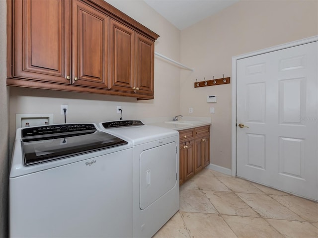 laundry room featuring washing machine and dryer, sink, and cabinets