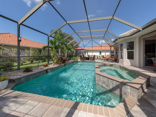 view of pool featuring glass enclosure, an in ground hot tub, and a patio