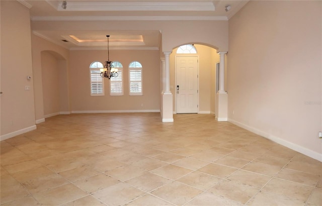 empty room with an inviting chandelier, ornate columns, crown molding, and a tray ceiling