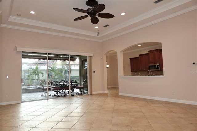 tiled spare room featuring ceiling fan, a raised ceiling, and crown molding