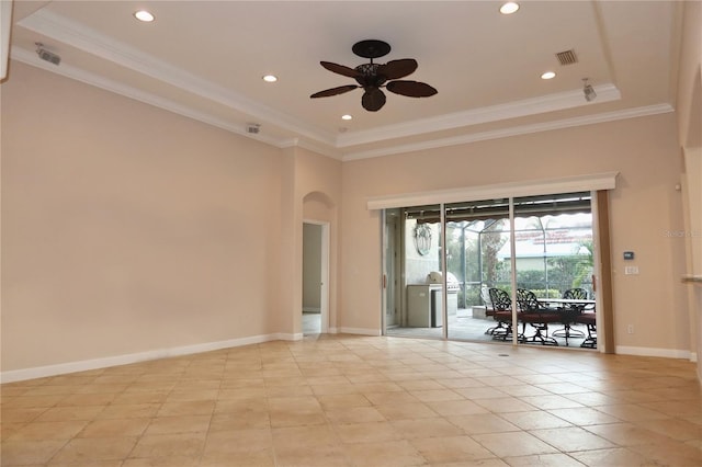 spare room with ceiling fan, crown molding, and a tray ceiling