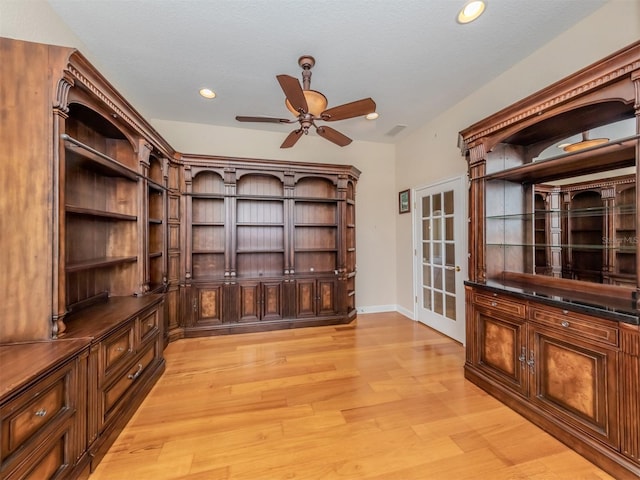 unfurnished office featuring a textured ceiling, light hardwood / wood-style flooring, and ceiling fan