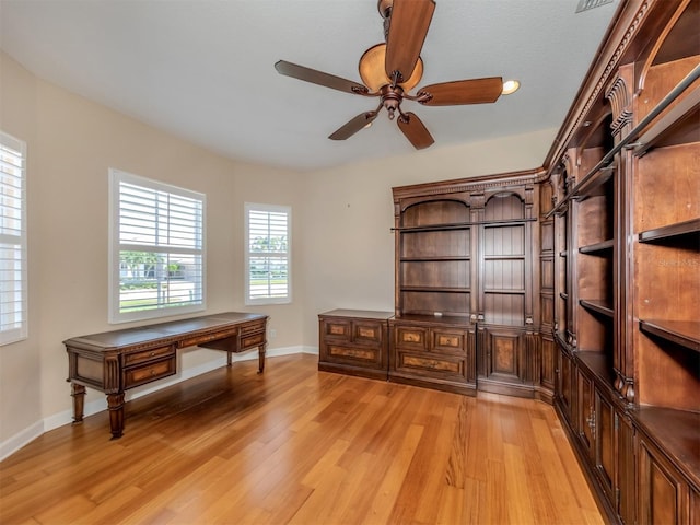 unfurnished office with ceiling fan and light wood-type flooring