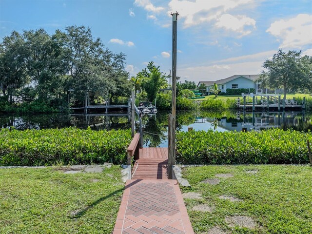 surrounding community with a lawn and a water view