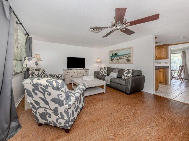 living room with ceiling fan and light hardwood / wood-style floors