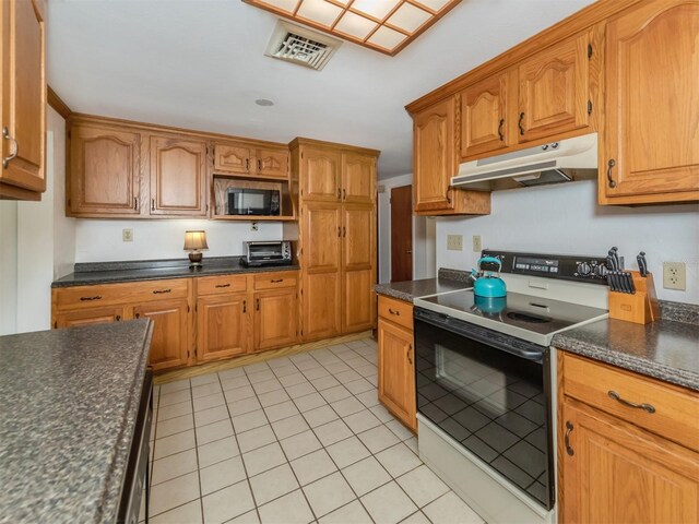 kitchen with light tile patterned flooring and white range with electric stovetop