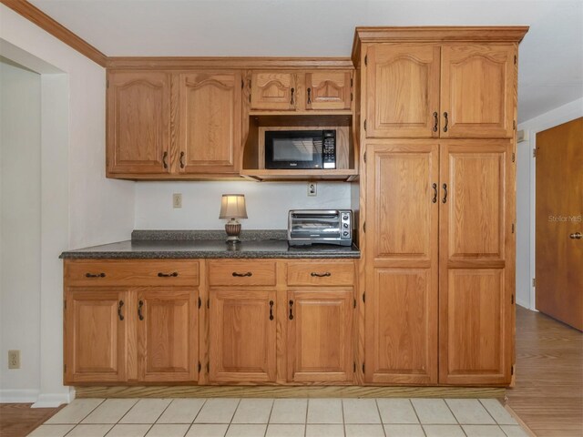 kitchen featuring light tile patterned floors and crown molding