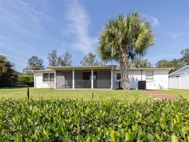 view of front of property with a front yard, cooling unit, and a sunroom