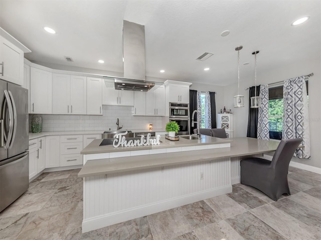2585 Hobblebrush Dr, North Port, FL 34289 - kitchen with island exhaust hood, a spacious island, backsplash, visible vents, and appliances with stainless steel finishes