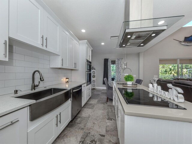 kitchen featuring appliances with stainless steel finishes, white cabinetry, light stone counters, backsplash, and sink