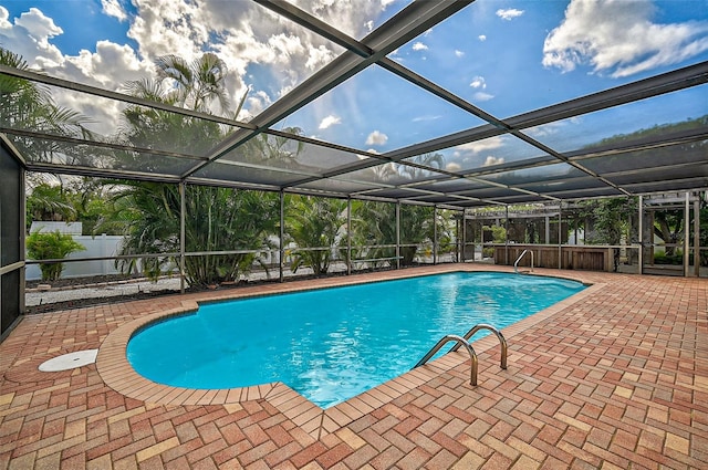 view of swimming pool featuring glass enclosure and a patio area