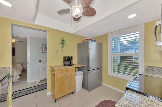 kitchen featuring ceiling fan, appliances with stainless steel finishes, and light tile patterned floors