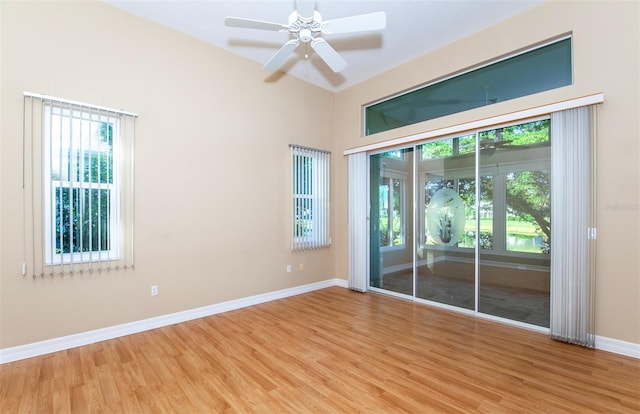 empty room with ceiling fan, plenty of natural light, and hardwood / wood-style floors