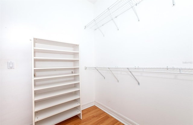 walk in closet with light hardwood / wood-style floors