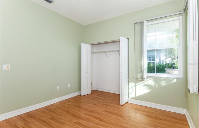 unfurnished bedroom featuring a closet and light hardwood / wood-style floors