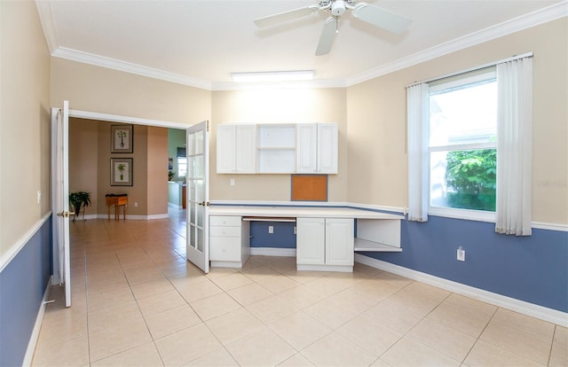 unfurnished office featuring ceiling fan, crown molding, built in desk, and light tile patterned floors