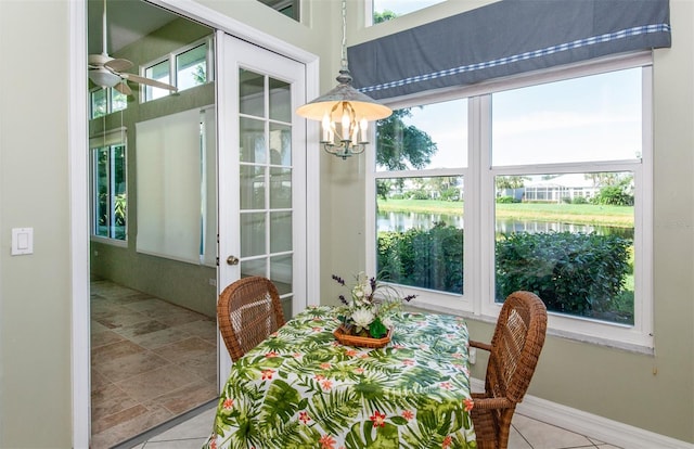 dining room featuring ceiling fan, a water view, and plenty of natural light