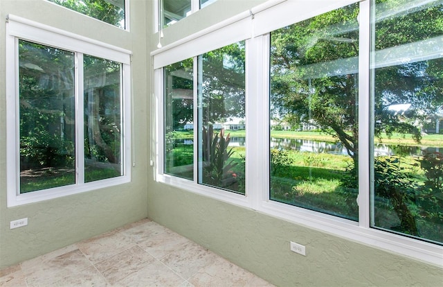 unfurnished sunroom with a water view