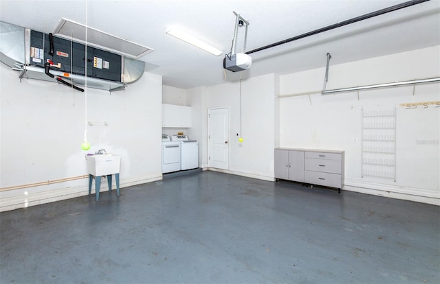 garage featuring sink, a garage door opener, and independent washer and dryer