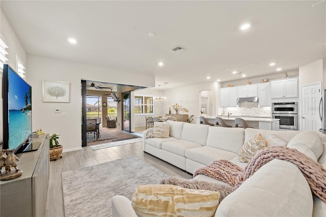 living room featuring an inviting chandelier and light hardwood / wood-style flooring