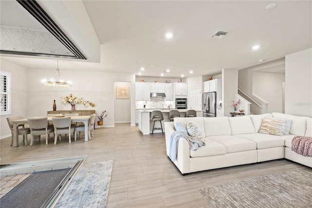 living room with a notable chandelier and light hardwood / wood-style floors