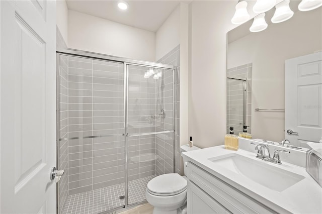 bathroom with an enclosed shower, vanity, and toilet