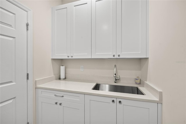 interior space featuring white cabinets and sink