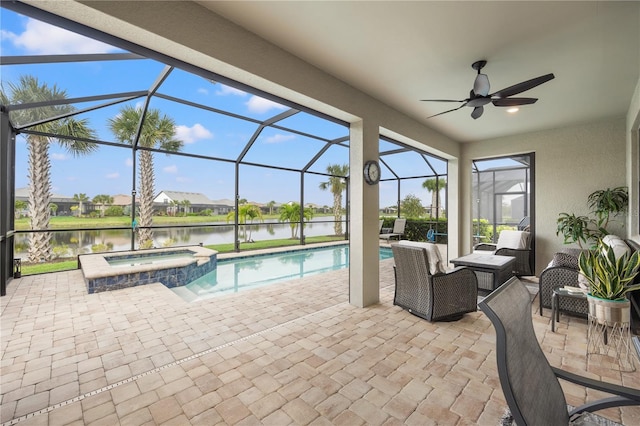 view of pool featuring a patio, a water view, an in ground hot tub, glass enclosure, and ceiling fan